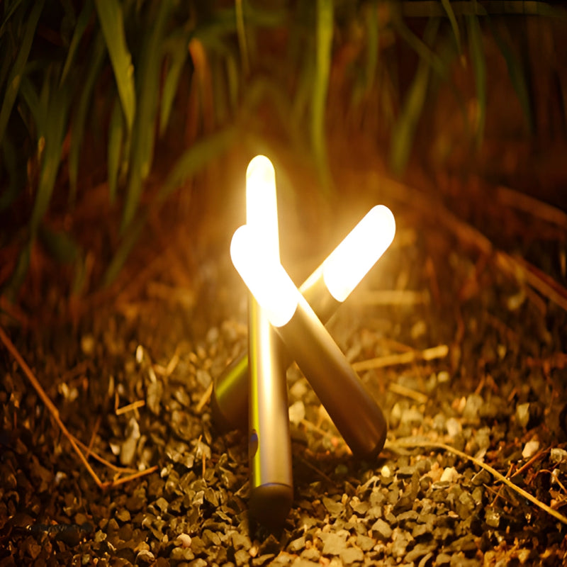 Cordless Kinetic Rotation LED Table Lamp placed on a wooden surface outdoors, surrounded by natural elements like grass and soil, with a warm lighting effect.