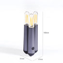 Cordless kinetic rotation LED table lamp featuring a cylindrical shape with metal body in electric blue and magenta, resembling audio equipment.