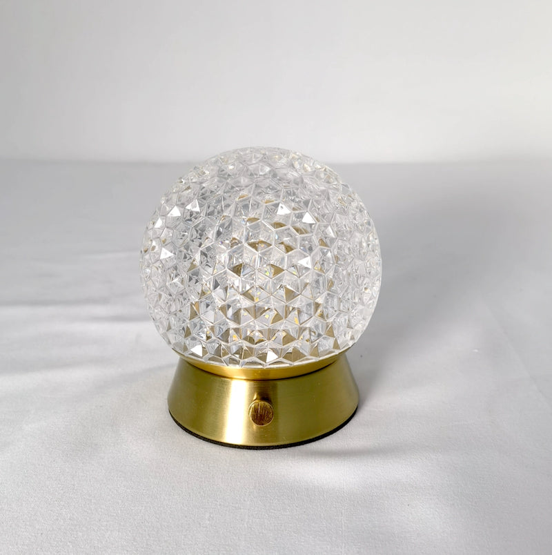 Modern design cordless rechargeable table lamp featuring a dimmable LED light, with a sleek silver metal and glass body, enhanced by gemstone-like embellishments.
