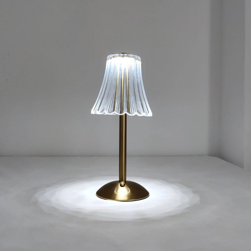 Cordless table lamp made of natural materials, featuring a wooden base and glass accents, displayed near a tree and plants, enhancing its beautiful design and supreme durability.
