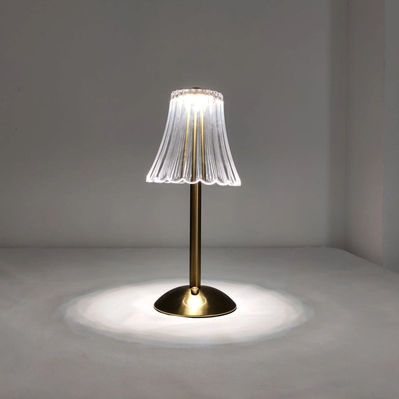 Cordless table lamp featuring a beautiful design with a wooden base and glass accents, surrounded by plants and art elements in a well-lit setting.