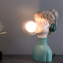 Green resin desk lamp in a minimalist design, featuring a light fixture and artistic elements, resembling a fictional character or toy.