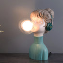 Resin desk lamp featuring a chic minimalist design, shaped like a fictional character with eye and head details, in orange and green colors.