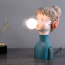 Chic minimalist orange desk lamp from the Resin Series, featuring a unique design resembling a human figure with a lamp head, gesture pose, and standing on a wooden base, measuring 3.9 inches in diameter, 4.7 inches in width, and 12.2 inches in height.