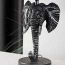 White and black elephant-shaped lamp featuring an artistic design with tusks, resembling an African elephant, crafted from materials that mimic bone.