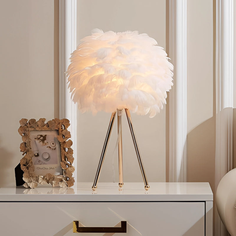Feather LED table lamp with dimmable lighting featuring a wood base and twig design, positioned against a wall in an artfully designed interior setting.
