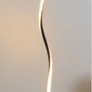 Modern floor lamp featuring a metal base and wooden accents, with a plant and artistic sculpture nearby, designed to offer three different light temperatures controlled by a remote.