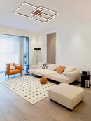 Modern artistic design geometric aluminum pendant light with LED technology, displayed in an interior setting featuring wooden flooring, a beige couch, and large windows.