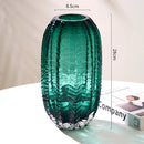 Green glass cactus-shaped vase with a wide circular base and textured design, resembling the look of a cactus.
