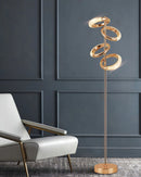 Gold floor lamp featuring a diamond-patterned shade with adjustable angles, crafted from metal and glass, set against a wooden flooring background.