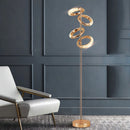Gold diamond-patterned floor lamp with adjustable angles, set in an interior featuring wooden flooring and a chair.
