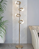 Gold diamond-patterned adjustable angles floor lamp set in a stylish interior with a wooden floor, plants, and art decorations.