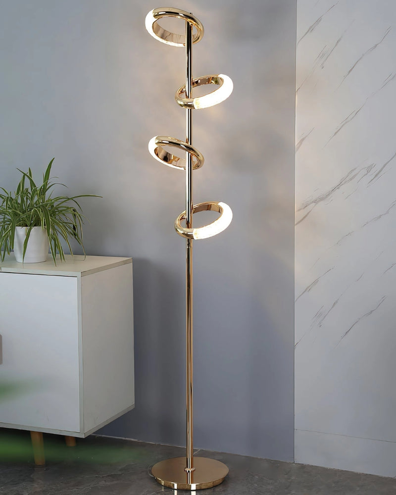 Gold diamond-patterned floor lamp with adjustable angles, featuring a sleek design set against a backdrop with a plant and wooden table.