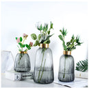 Green glass vase for hydroponic plants featuring a Nordic design, displayed with a variety of houseplants and flowering plants.