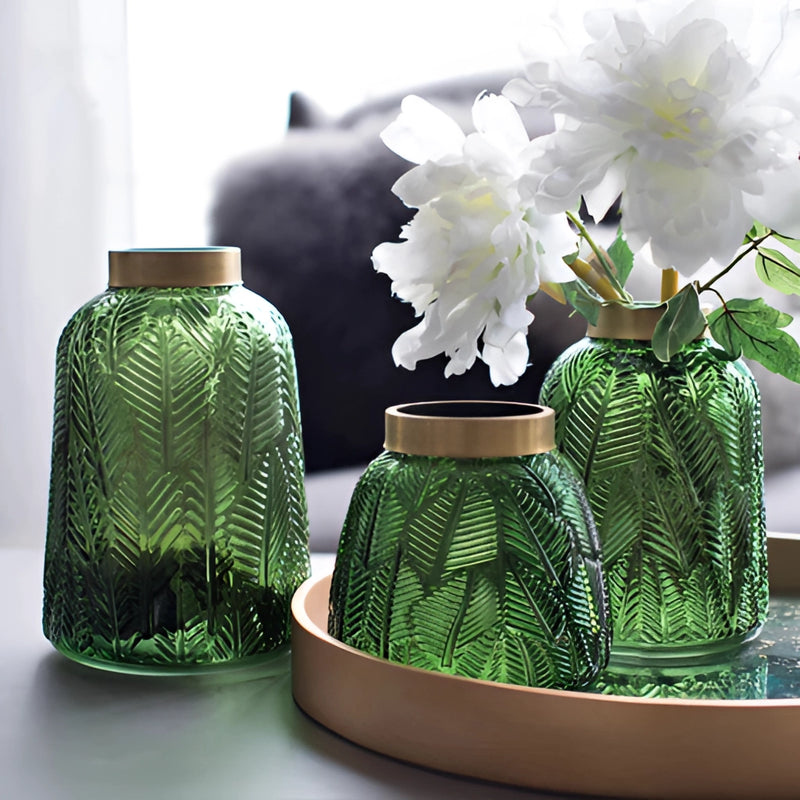 Green glass vase designed for hydroponic plants featuring a Nordic design, filled with flowers and greenery.