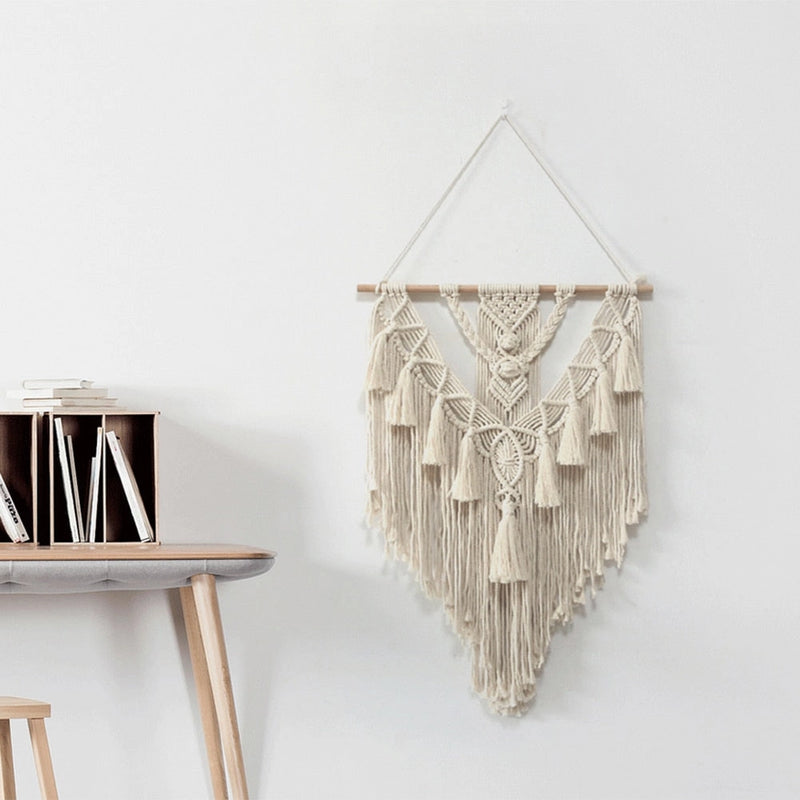 Handwoven Macrame Boho wall hanging tapestry featuring geometric art decor, displayed on a wood shelf with metal and twig accents.
