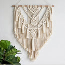 Handwoven macrame boho wall hanging tapestry featuring geometric patterns, accented with wood, metal elements, and feather details.