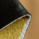 Rectangular PVC rug mat featuring a tropical pattern, displayed with various fashion accessories including a bag and metal elements, set against a shaded background.