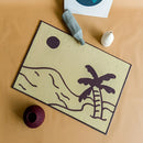 Rectangular indoor/outdoor tropical Aloha PVC rug mat with a vibrant pattern and artistic illustration, displayed on a wooden surface.