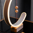 Interior lamp featuring magnetic switches, crescent-shaped glow, with wooden and metal elements, and artistic rectangular and circular designs.