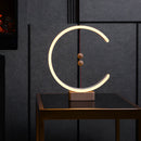 Wall-mounted interior lamp featuring a crescent-shaped glow, wooden rectangular frame with circular magnetic switches, and metal accents.