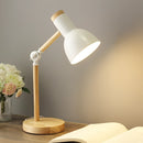 White LED desk lamp featuring a Scandinavian minimalist design with a wooden base, adjustable lighting options, and a plant beside it, enhancing a comfortable and balanced ambiance.