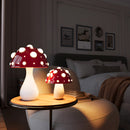 LED Mushroom Table Lamp with warm white light on a desk, surrounded by cozy interior furnishings including a picture frame and textiles.