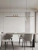 Nordic-inspired sleek design LED pendant light hanging over a modern white dining table surrounded by chairs in a room with wood flooring and cabinetry.