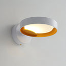 Contemporary LED wall light featuring an artistic iron and acrylic sconce design, with elements resembling circular and cylindrical shapes, highlighted under fluorescent lighting.