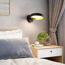 Contemporary iron and acrylic LED wall light sconce with an artistic design, featuring elements like a flowerpot and plant, enhancing the warm and comfortable ambiance of an interior setting.