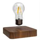 Levitating LED desk lamp with a glowing light bulb floating above a walnut base, connected by a subtle cable for electricity.
