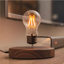 Levitating LED desk lamp with a glowing amber light and a stylish walnut base, displayed on a table.