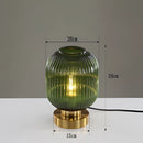 Green luminescent crystal table lamp featuring a glass and metal design with artistic detailing, approximately 20cm in height.