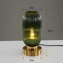 Green luminescent crystal table lamp in a cylindrical shape made of glass and metal, featuring a transparent design with aluminum accents, measuring 13cm.