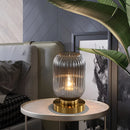 Crystal table lamp with a luminescent glow, set on a wooden table, enhancing the interior design of the room.