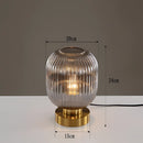 Smoky gray luminescent crystal table lamp, featuring a 20cm glass and metal base with glowing amber light, designed in a sleek, modern style.