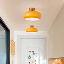 Modern luxury chandelier from the Jaxon Glass Pendant Light series featuring LED bulbs, displayed in a room with yellow and orange painted walls and wooden accents.