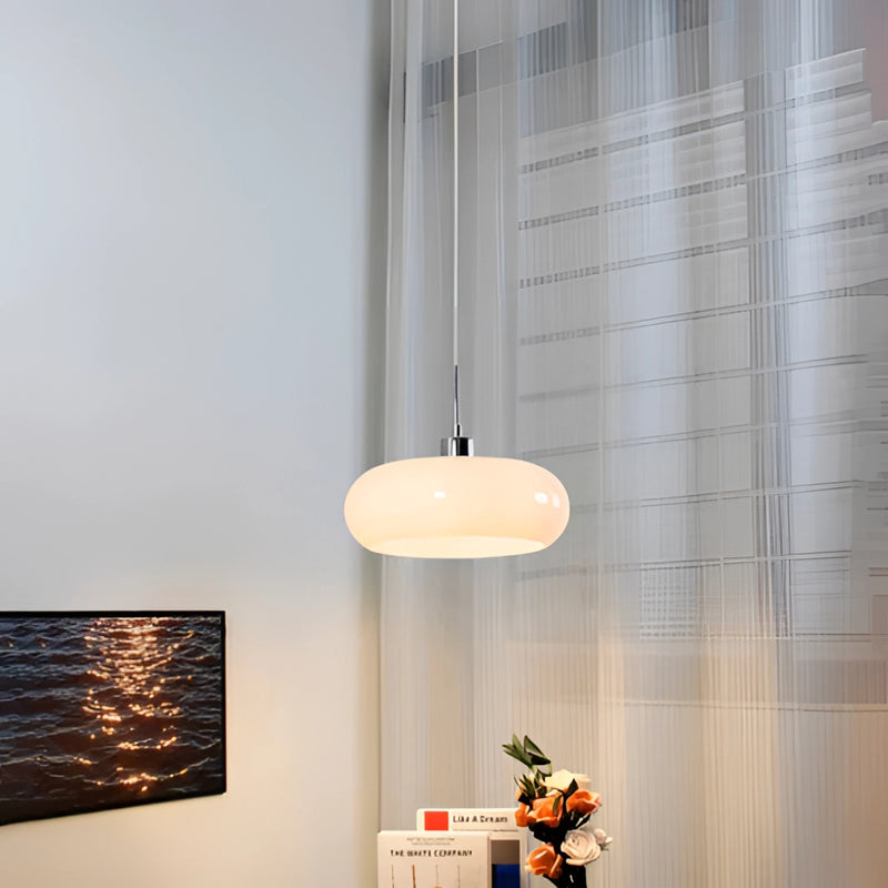 Modern Jaxon glass pendant light featuring a luxury chandelier with LED bulbs, set in a room with wooden elements, shaded ceiling, and houseplants, enhancing a contemporary aesthetic.