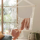 White macramé hammock swing made from textile and wood, featuring a comfortable design with a pattern, shades, and tints, suitable for garden or room use.