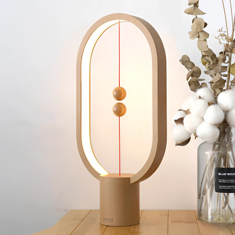 Magnetic balance table lamp featuring a rectangular wooden base with metal accents and an LED light fixture, artistically designed with twig and hardwood elements.