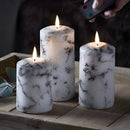 Set of three marble-patterned LED flameless candles in varying heights, displayed with a soft, glowing light.