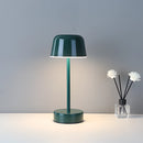 Green Pulse Flare metal table lamp with adjustable brightness, featuring a floral design in a vase on a glass table.
