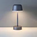 Dark gray Pulse Flare metal table lamp with adjustable brightness featuring an electric blue tint, artistic design elements, lampshade, and circular light fixture casting shadows.