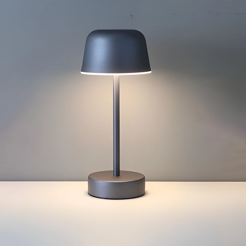 Dark gray Pulse Flare metal table lamp with adjustable brightness featuring an electric blue tint, artistic design elements, lampshade, and circular light fixture casting shadows.