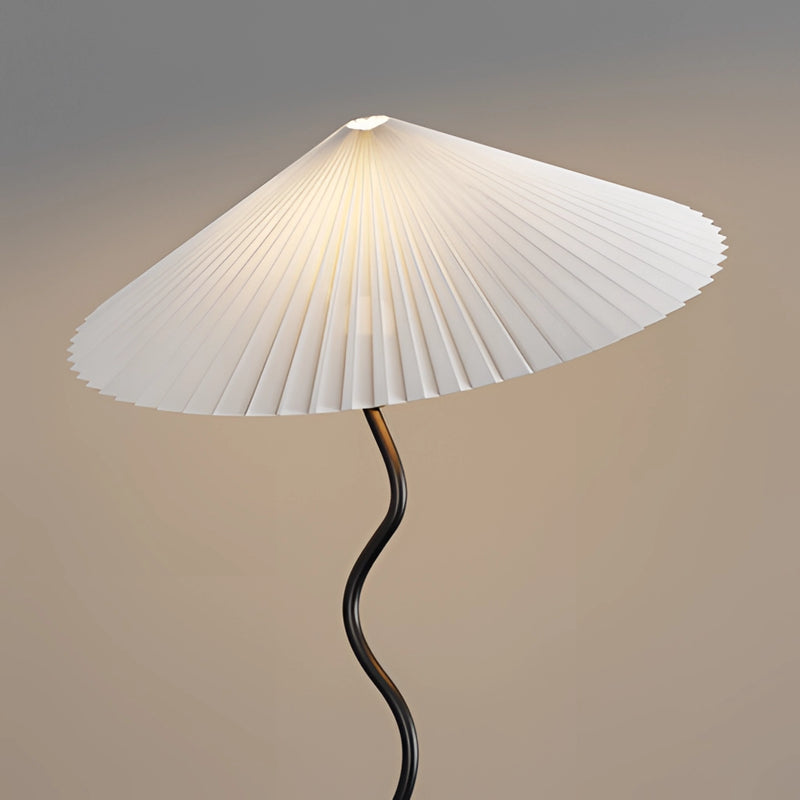 Metal textile curved pleated floor lamp with a lampshade, featuring tints and shades on a wooden base with artistic ceiling fixture elements.