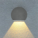 Modern LED wall sconce in sand black and grey, featuring a symmetrical pattern with circular and rectangular elements, and crafted from aluminum and borosilicate glass. The design includes artful shadows and tints of electric blue.