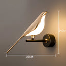 Gold modern rotatable wall sconce with a 360-degree lampshade, featuring a warm light and installed on a wood surface.