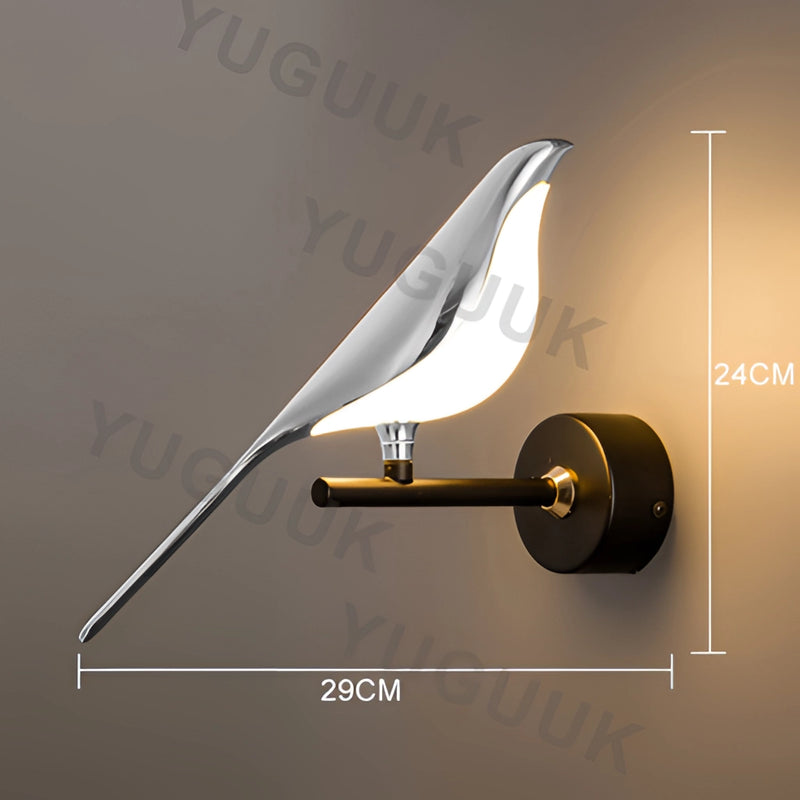Gold wall sconce with a rotatable 360-degree lampshade in a silvery finish, emitting a warm light.