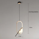 Modern rotatable wall sconce with a 360-degree ellipse-shaped lampshade in gold, featuring a warm light. The design includes metallic and glass elements, resembling a stylish fashion accessory.