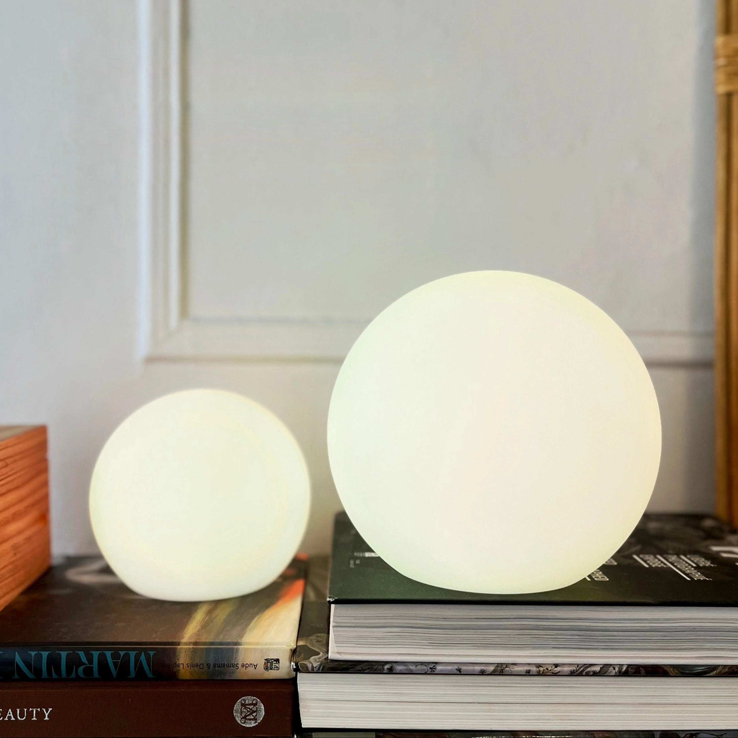 Cordless LED table lamp designed to resemble the moon, 6 inches in size, displayed on a wooden table with hardwood flooring in the background.